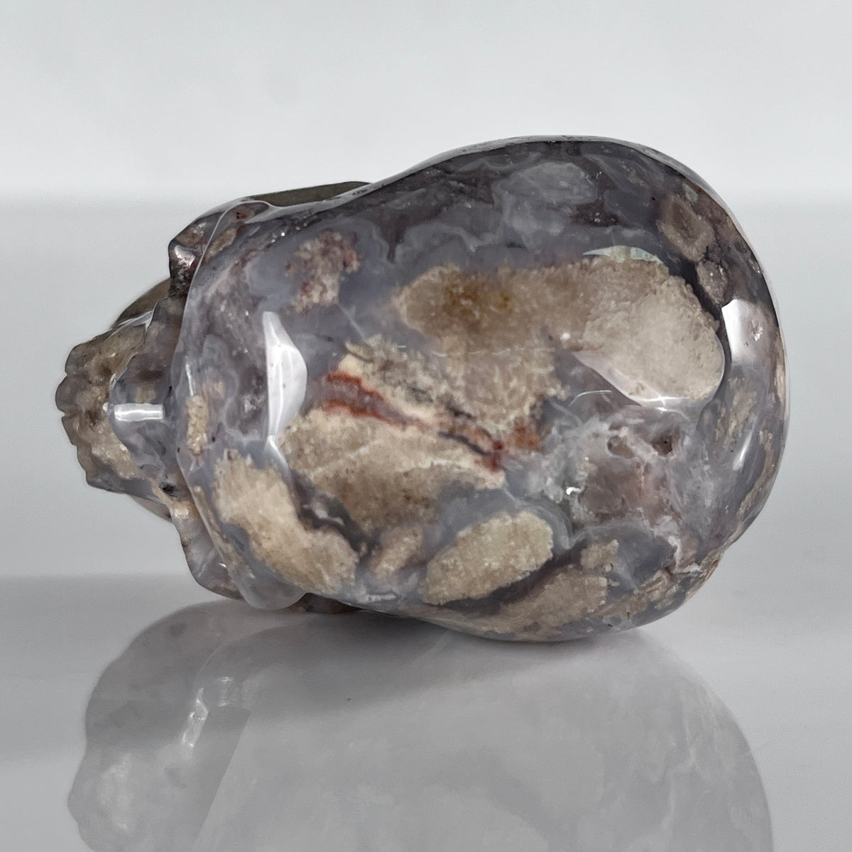 Top view of a 2-inch Blue Flower Agate human skull carving