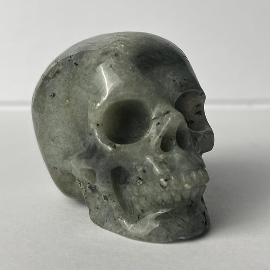 Right-front view of a 2-inch Grey Labradorite human skull carving