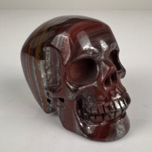 Right-front view of a 2-inch Tiger Iron human skull carving