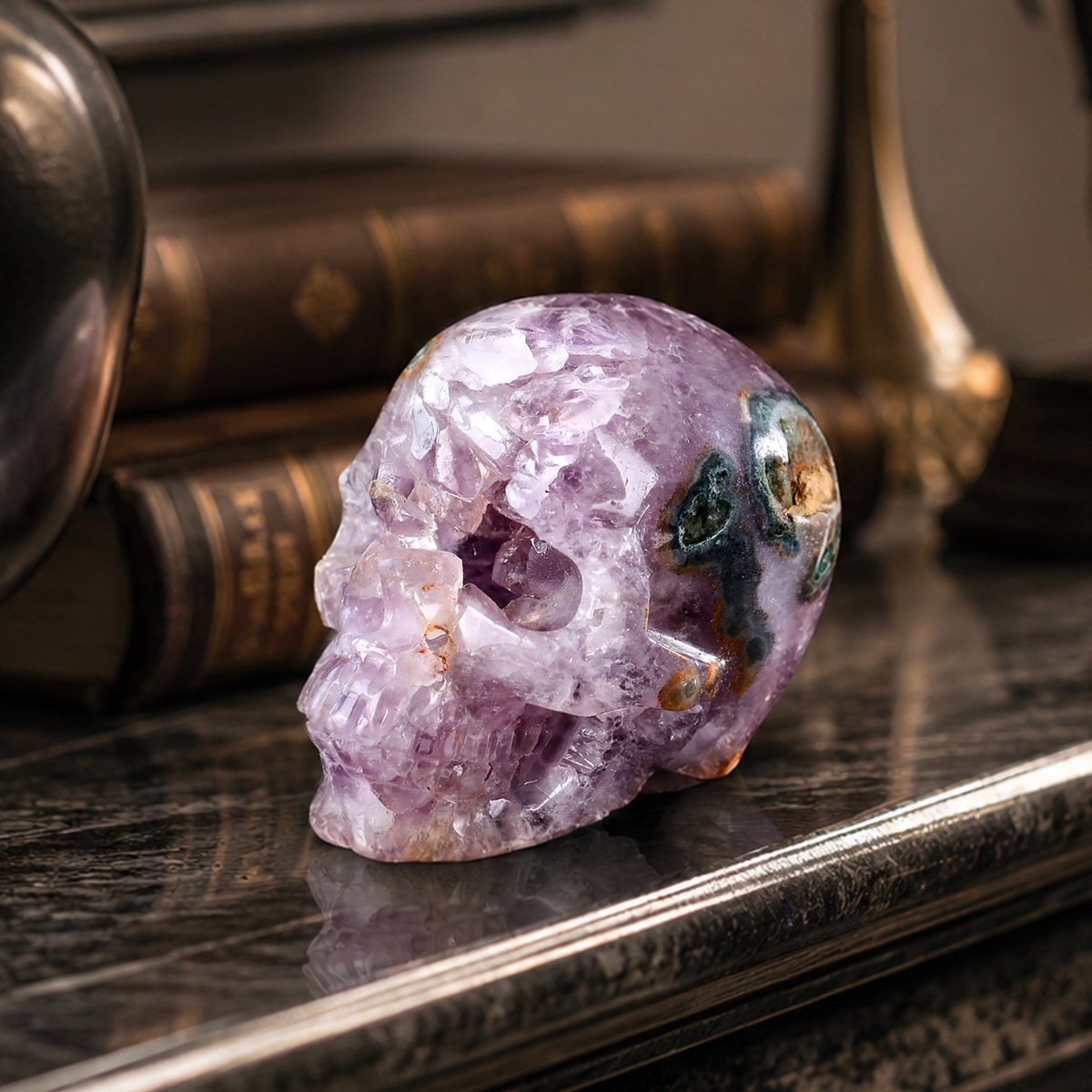 Purple stone skull sculpture displayed beside a book