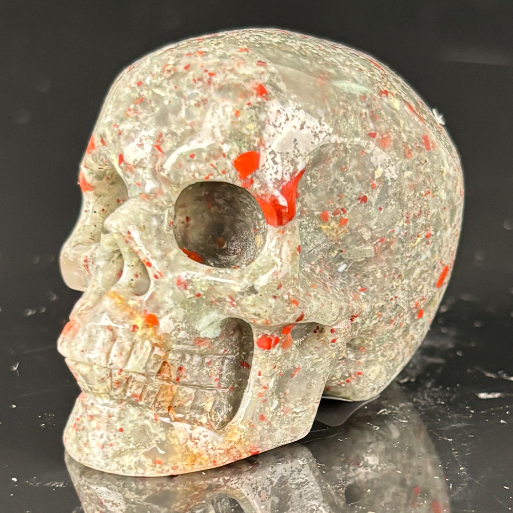 Left-front view of a 2-inch African Bloodstone human skull carving