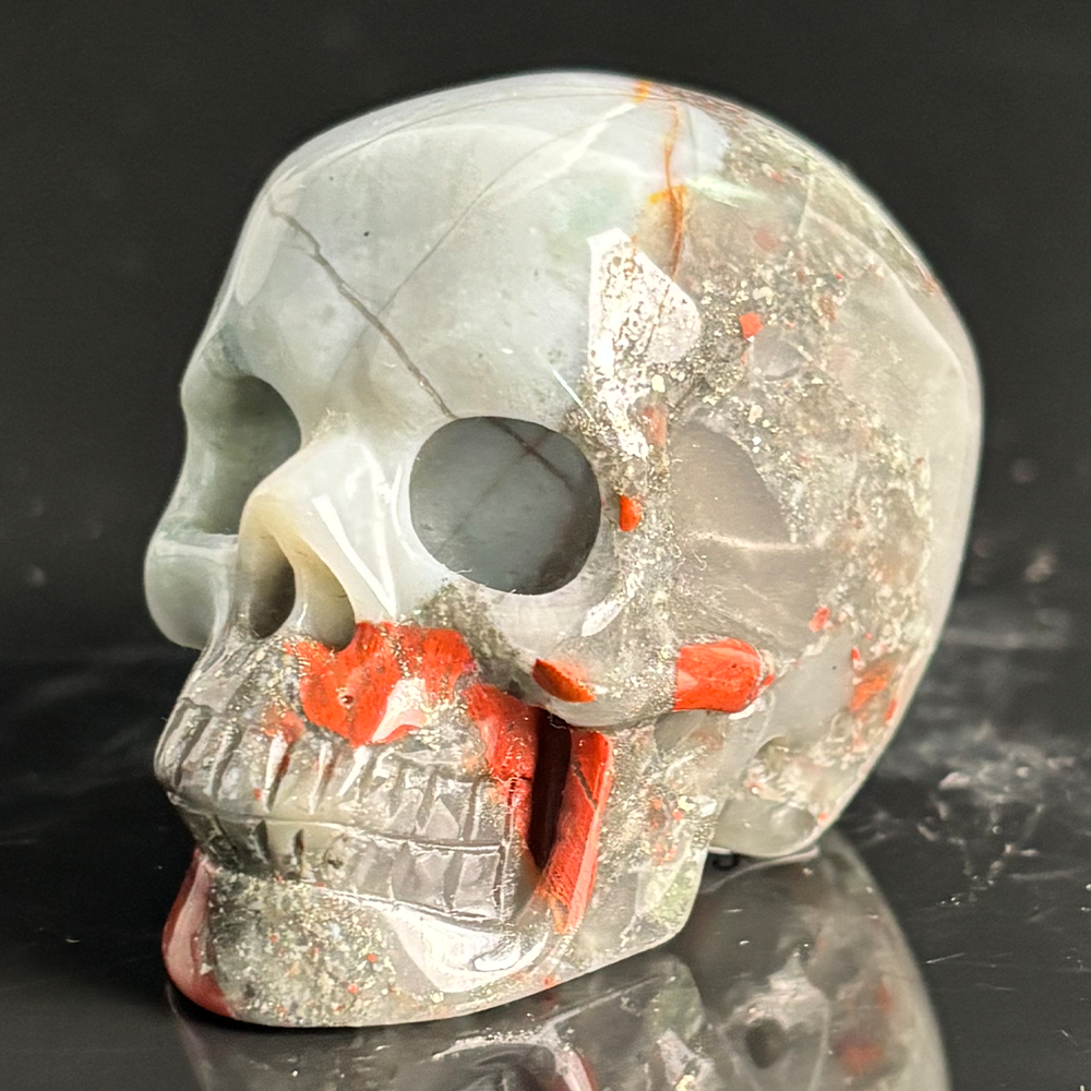 Left-front view of a 2-inch African Bloodstone human skull carving