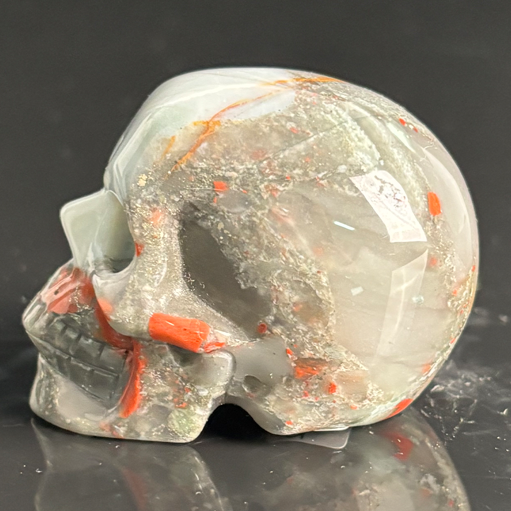 Left view of a 2-inch African Bloodstone human skull carving