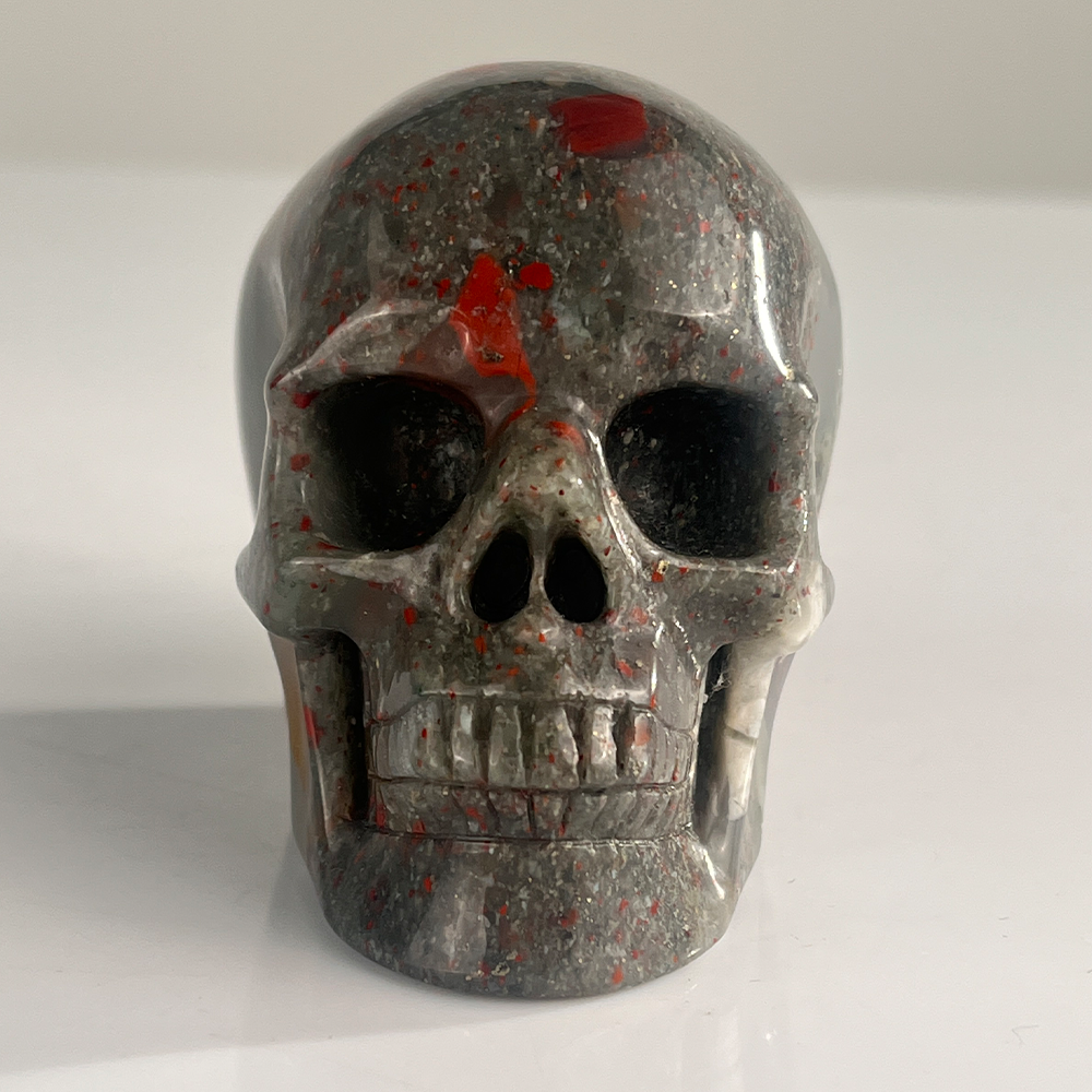 Front view of a 3-inch African Bloodstone human skull carving