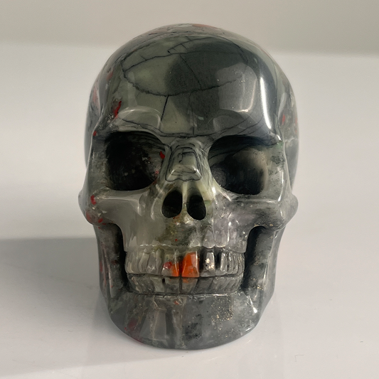 Front view of a 3-inch African Bloodstone human skull carving