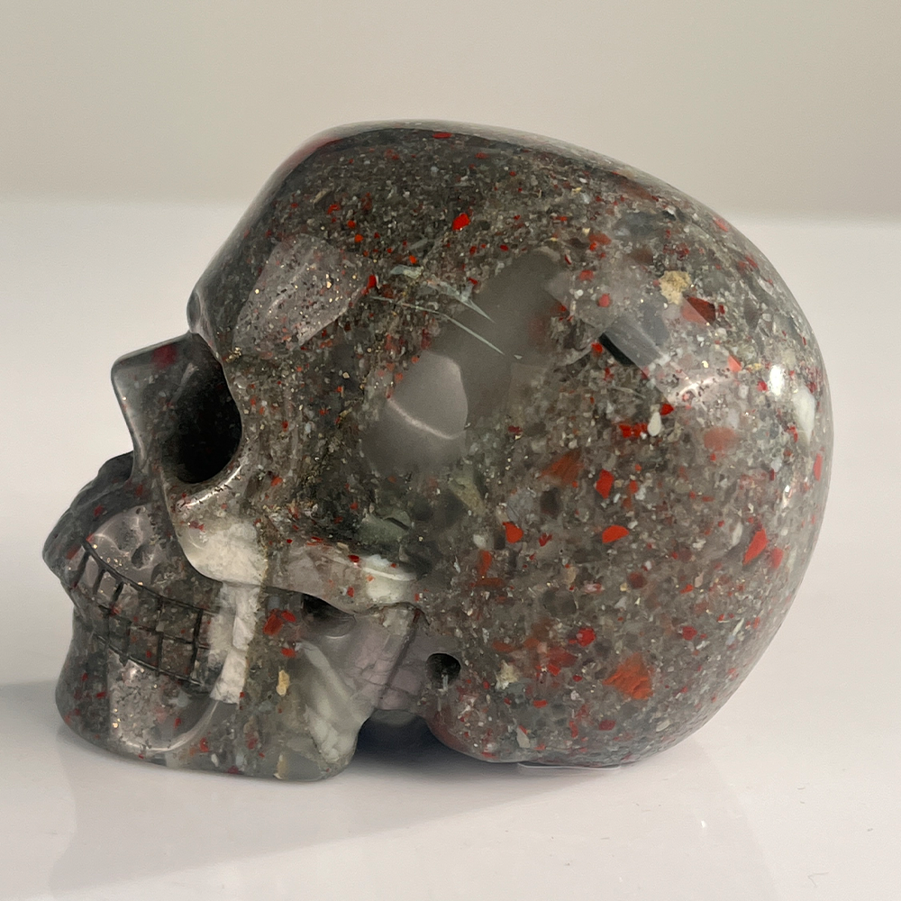 Left view of a 3-inch African Bloodstone human skull carving