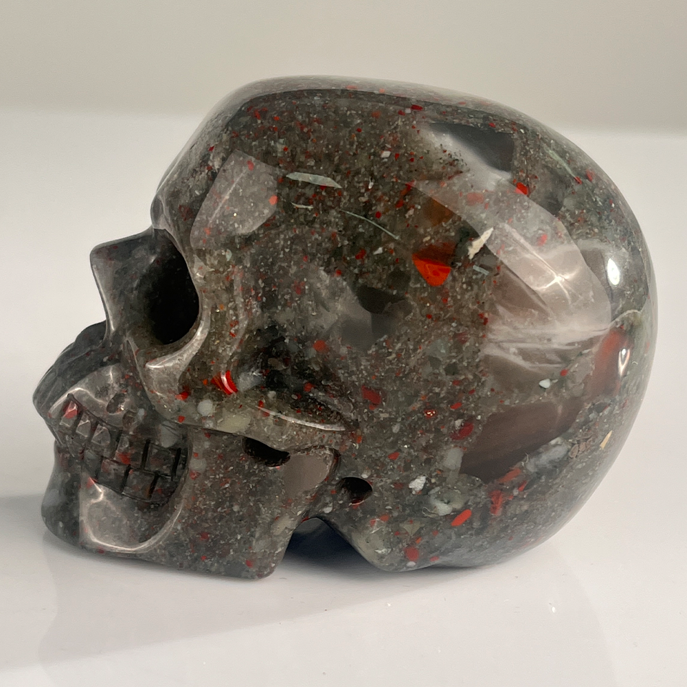 Left view of a 3-inch African Bloodstone human skull carving