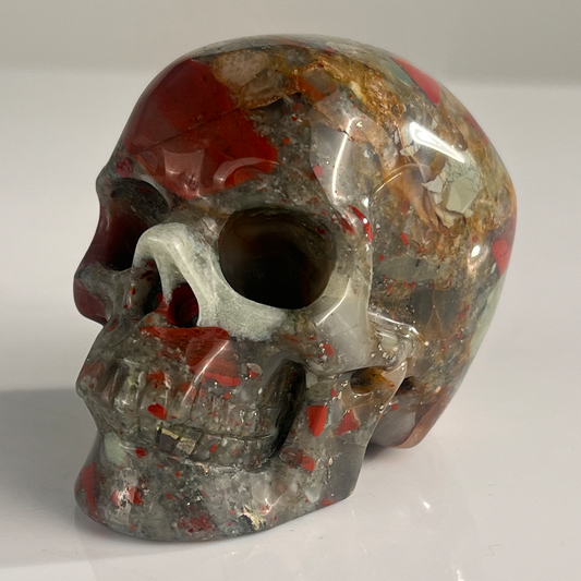Left-front view of a 3-inch African Bloodstone human skull carving