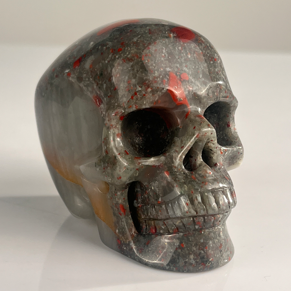 Right-front view of a 3-inch African Bloodstone human skull carving