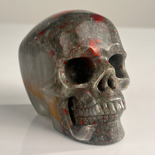 Right-front view of a 3-inch African Bloodstone human skull carving