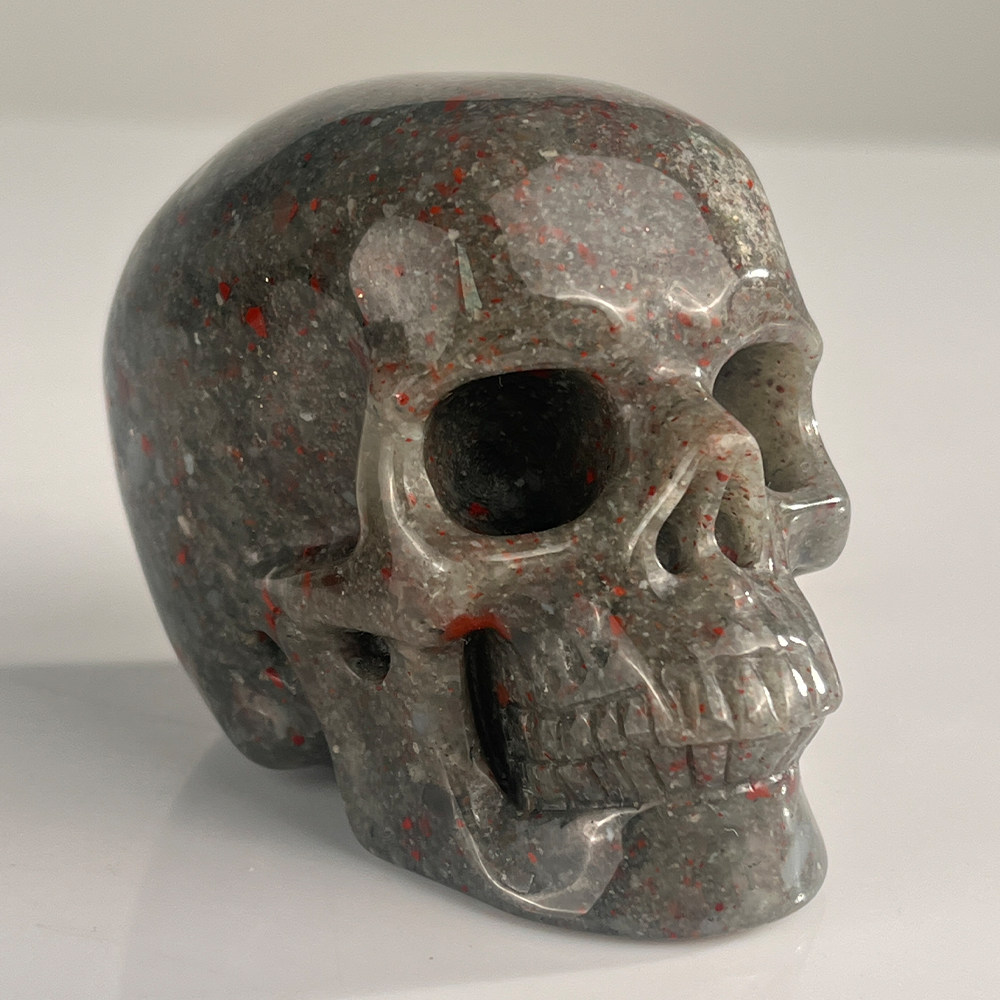 Right-front view of a 3-inch African Bloodstone human skull carving