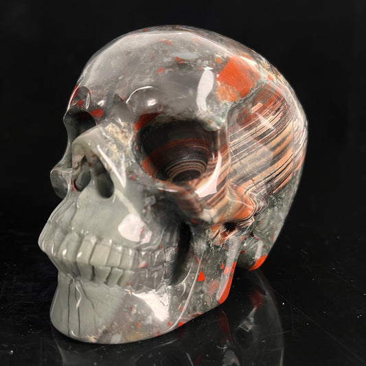 Left-front view of a 4.5-inch African Bloodstone human skull carving