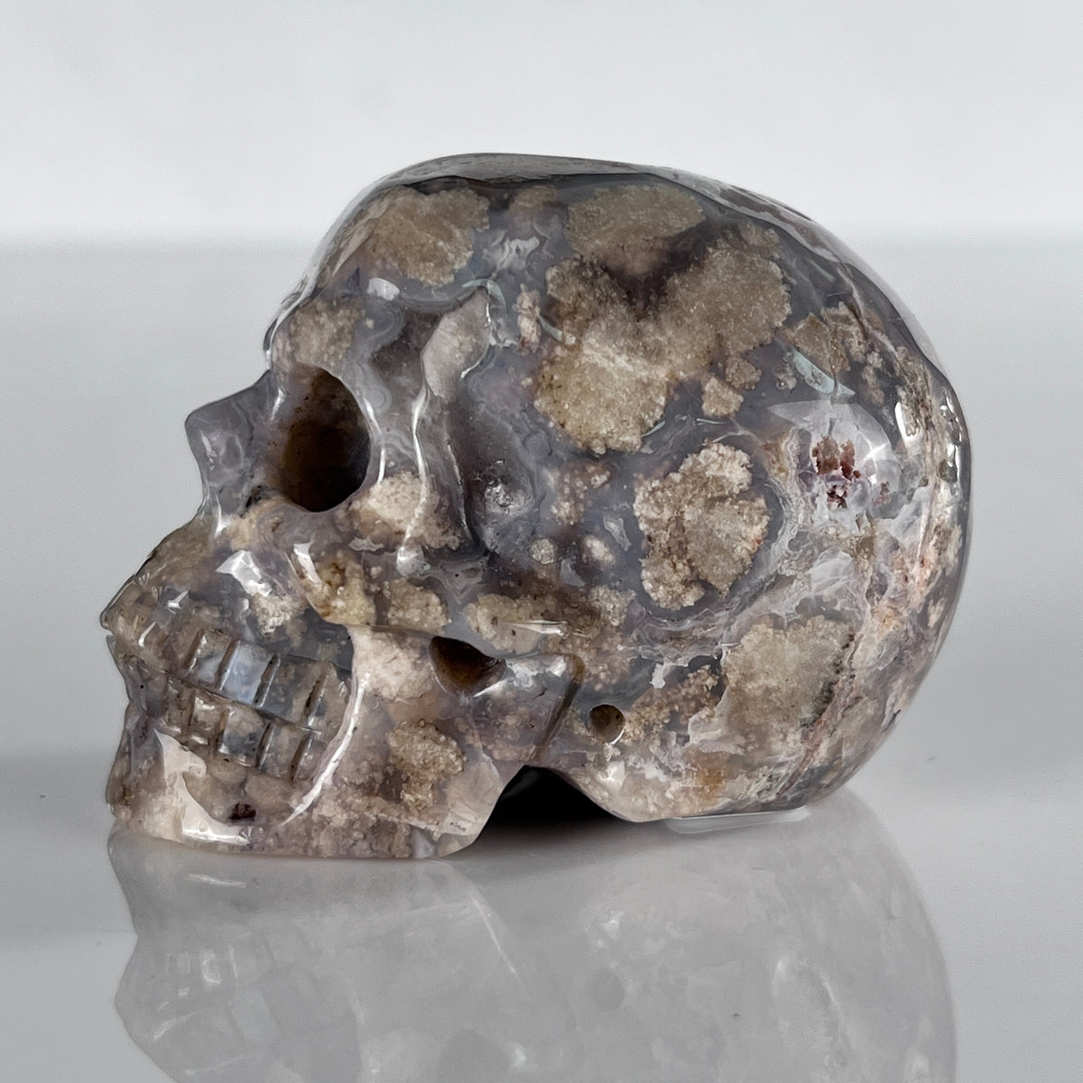 Left view of a 2-inch Blue Flower Agate human skull carving