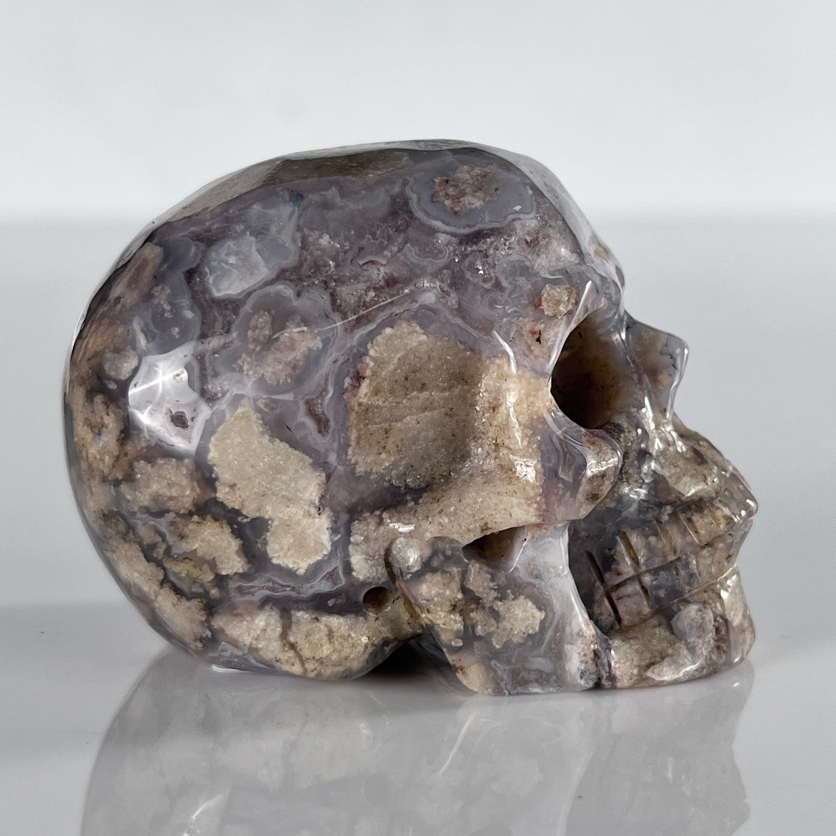 Right view of a 2-inch Blue Flower Agate human skull carving