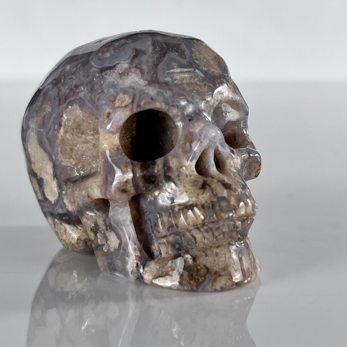 Right-front view of a 2-inch Blue Flower Agate human skull carving