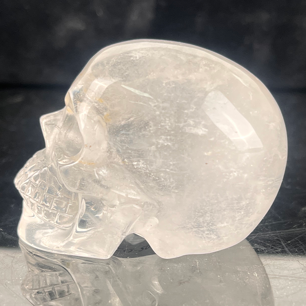 Left view of a 2-inch Clear Quartz human skull carving