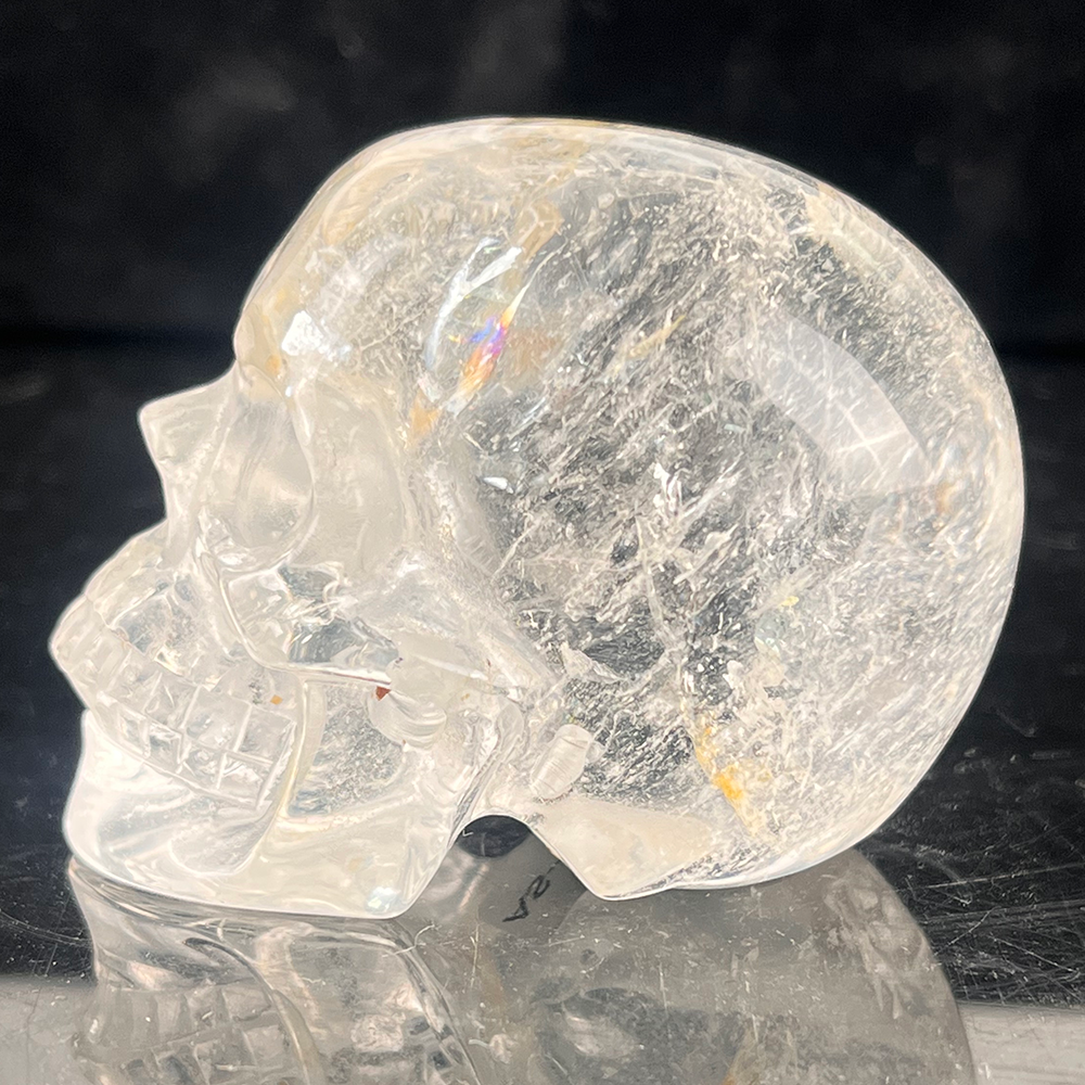 Left view of a 2-inch Clear Quartz human skull carving