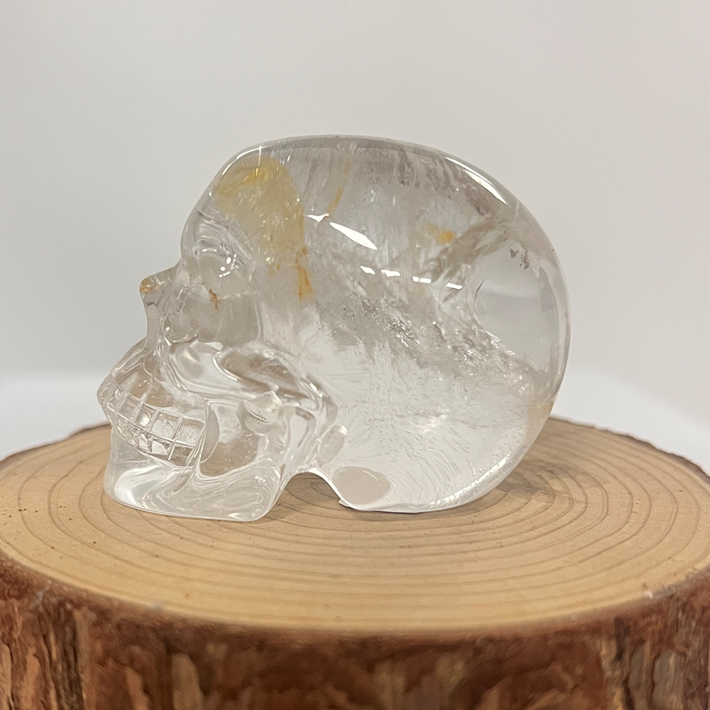 Left view of a 2-inch Clear Quartz human skull carving