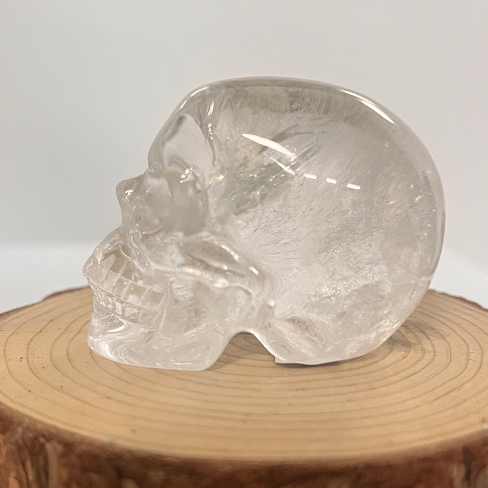 Left view of a 2-inch Clear Quartz human skull carving