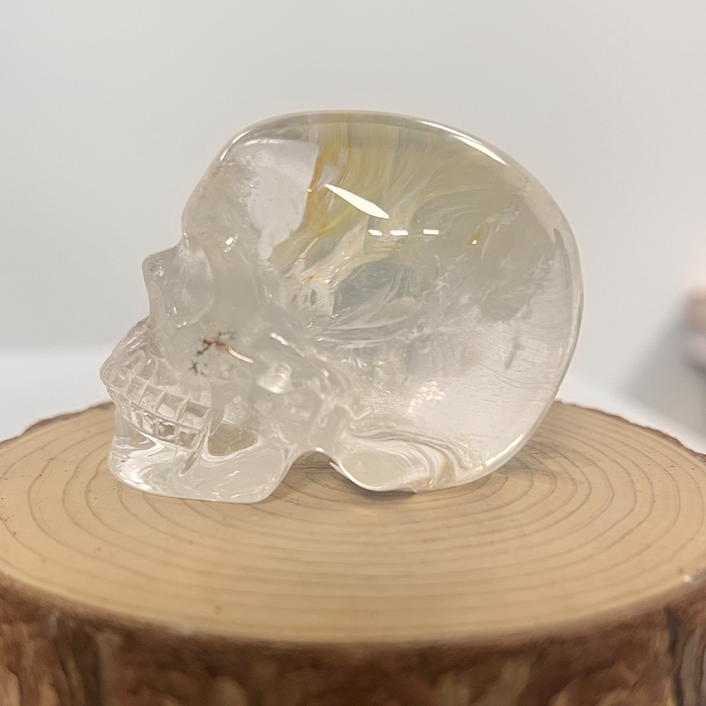Left view of a 2-inch Clear Quartz human skull carving