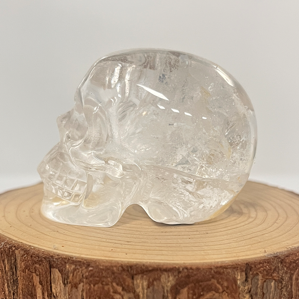 Left view of a 2-inch Clear Quartz human skull carving