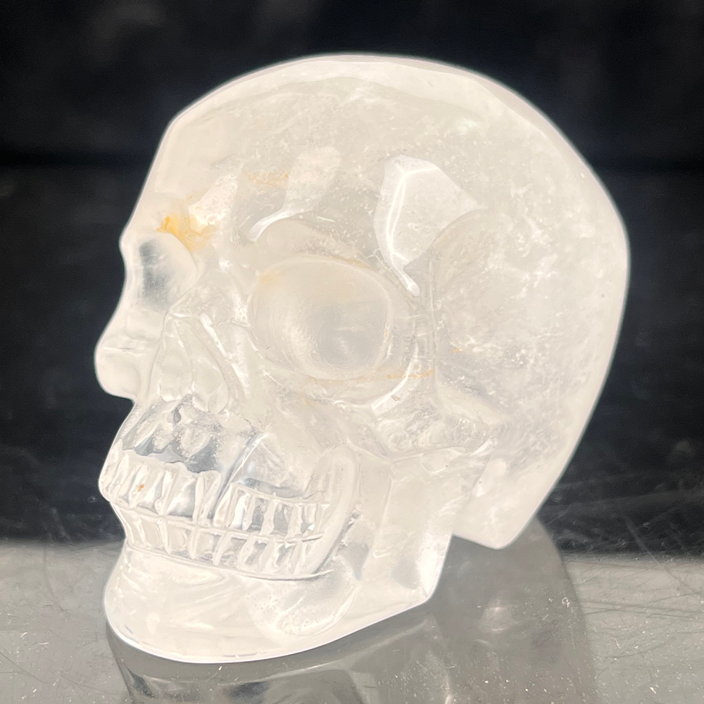 Left-front view of a 2-inch Clear Quartz human skull carving