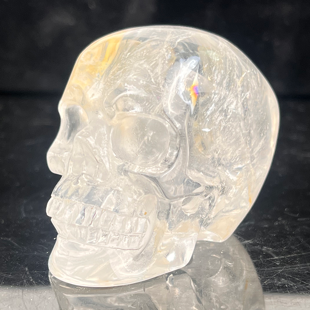 Left-front view of a 2-inch Clear Quartz human skull carving