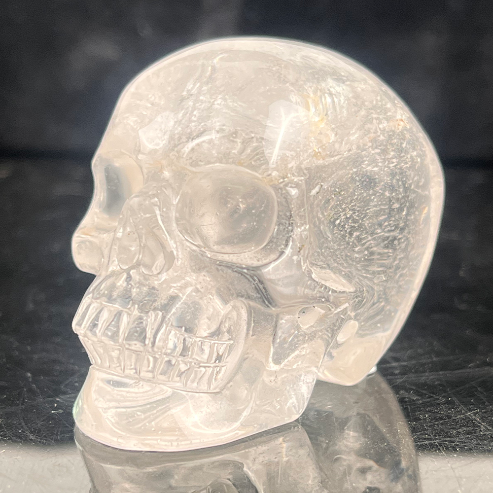 Left-front view of a 2-inch Clear Quartz human skull carving