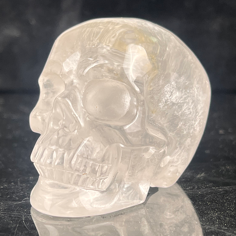 Left-front view of a 2-inch Clear Quartz human skull carving