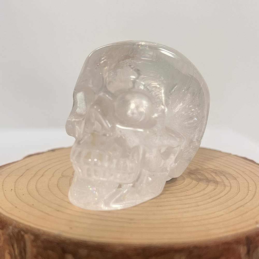 Left-front view of a 2-inch Clear Quartz human skull carving