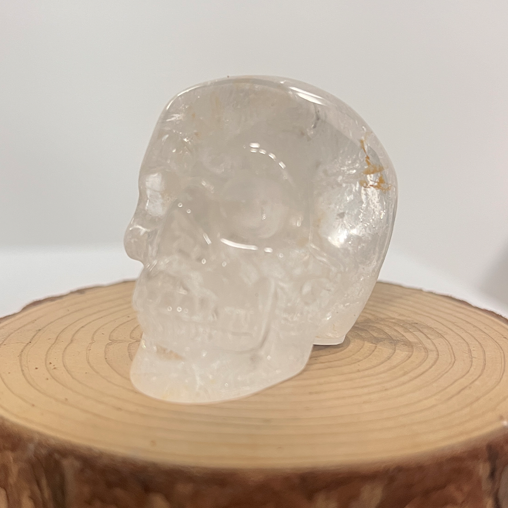 Left-front view of a 2-inch Clear Quartz human skull carving