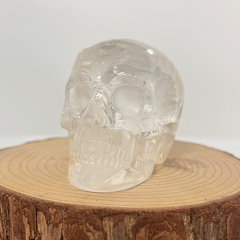 Left-front view of a 2-inch Clear Quartz human skull carving