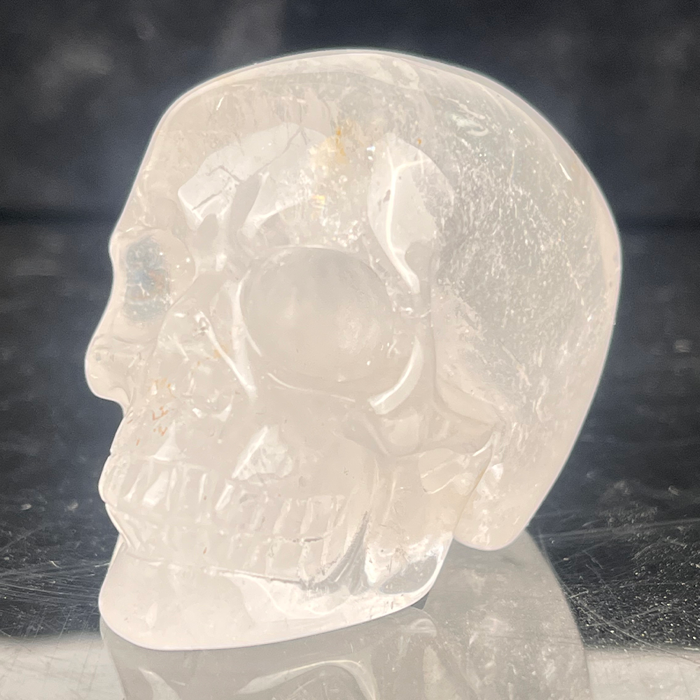 Left-front view of a 2-inch Clear Quartz human skull carving