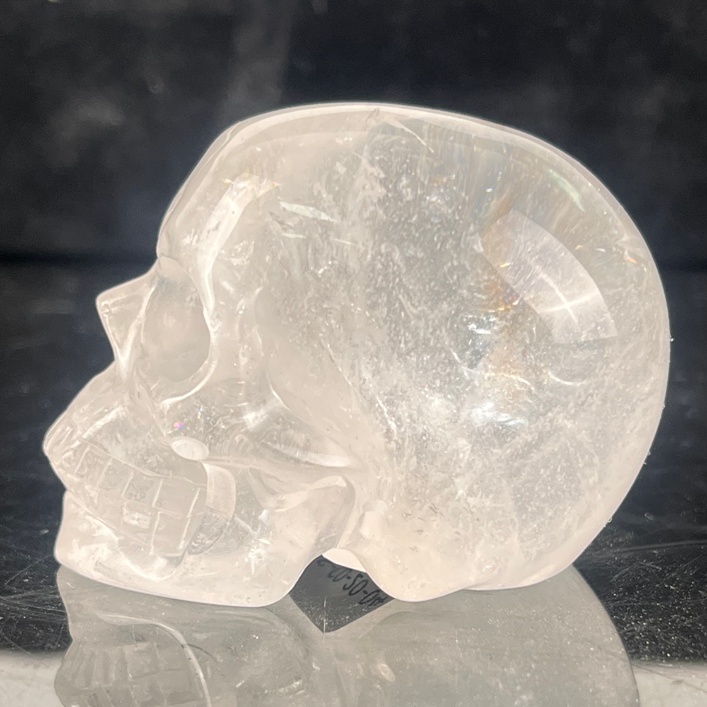 Left view of a 2-inch Clear Quartz human skull carving