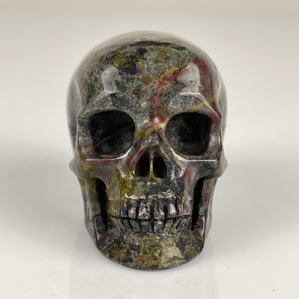 Front view of a 2-inch Dragon Bloodstone human skull carving