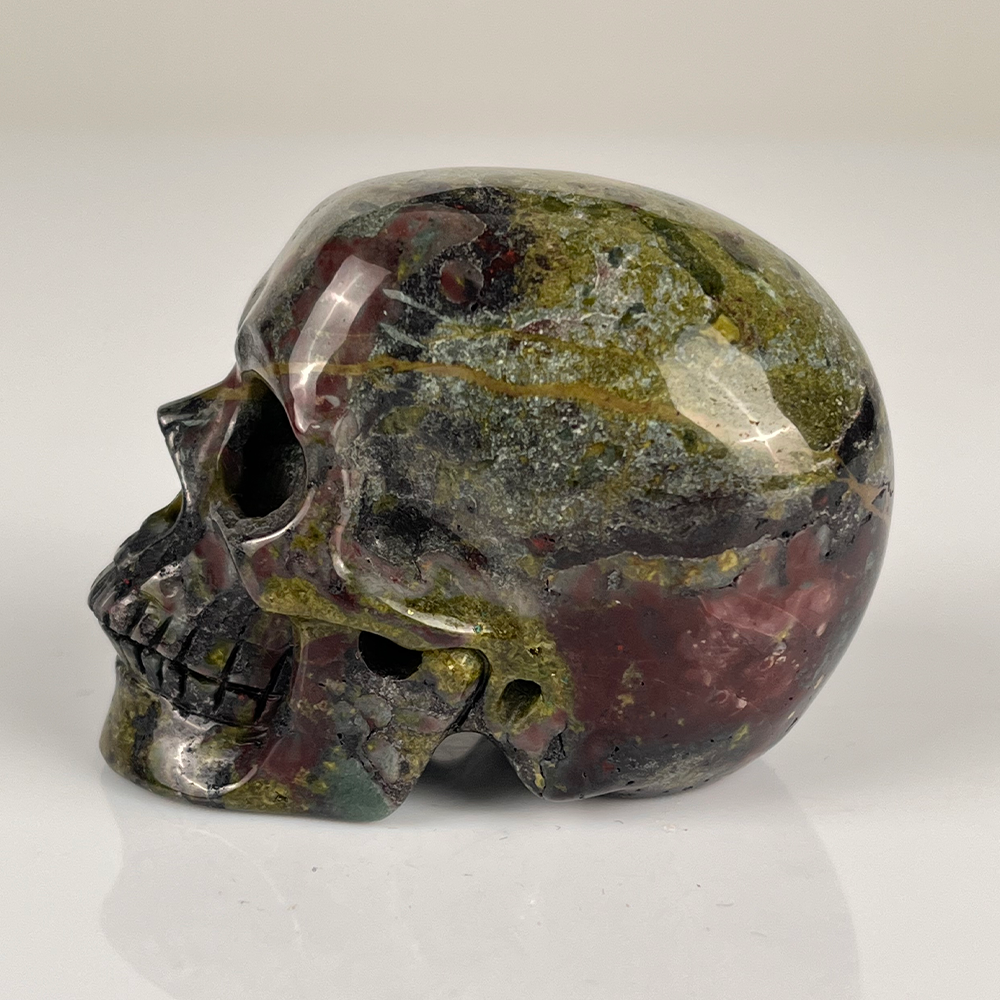 Left view of a 2-inch Dragon Bloodstone human skull carving