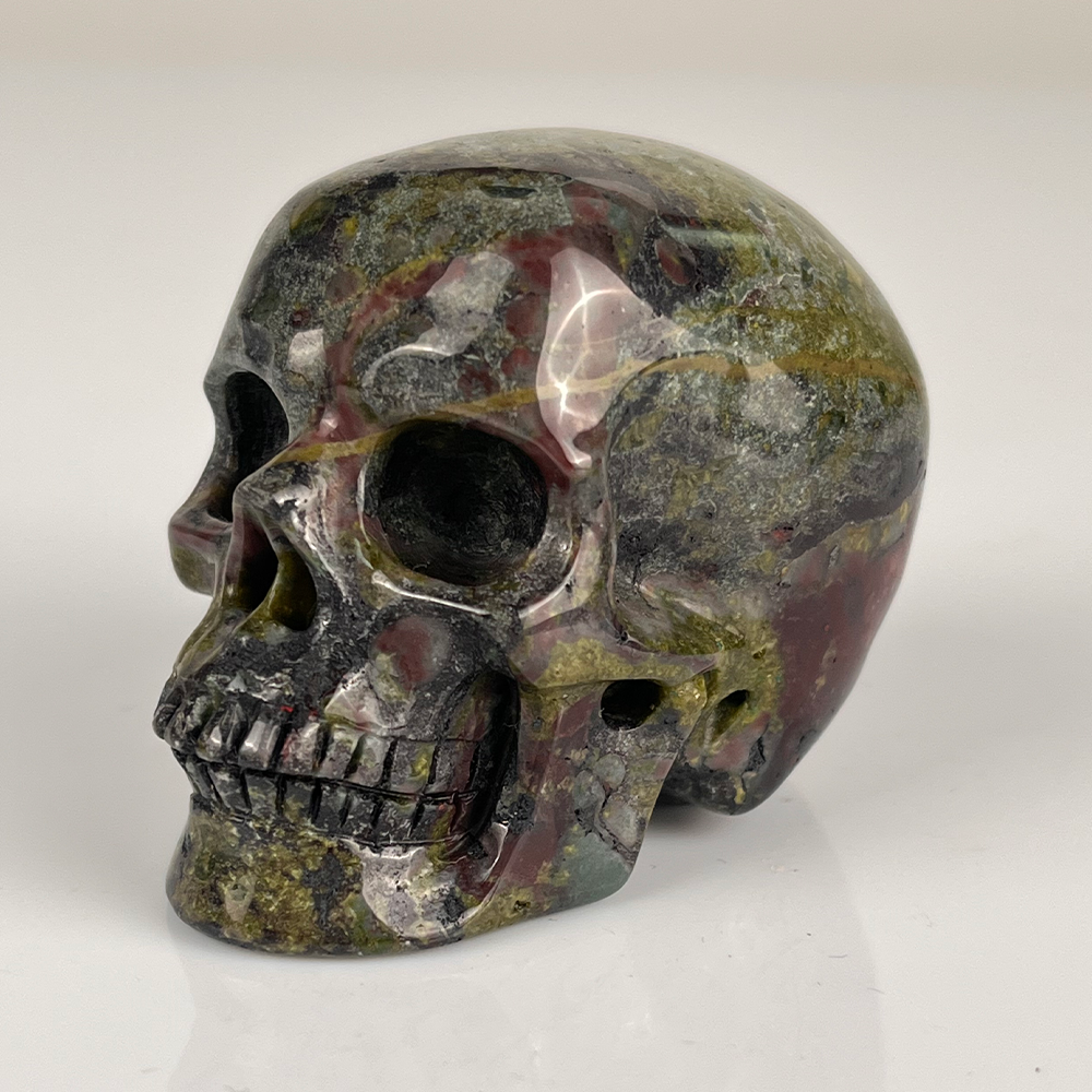 Left-front view of a 2-inch Dragon Bloodstone human skull carving