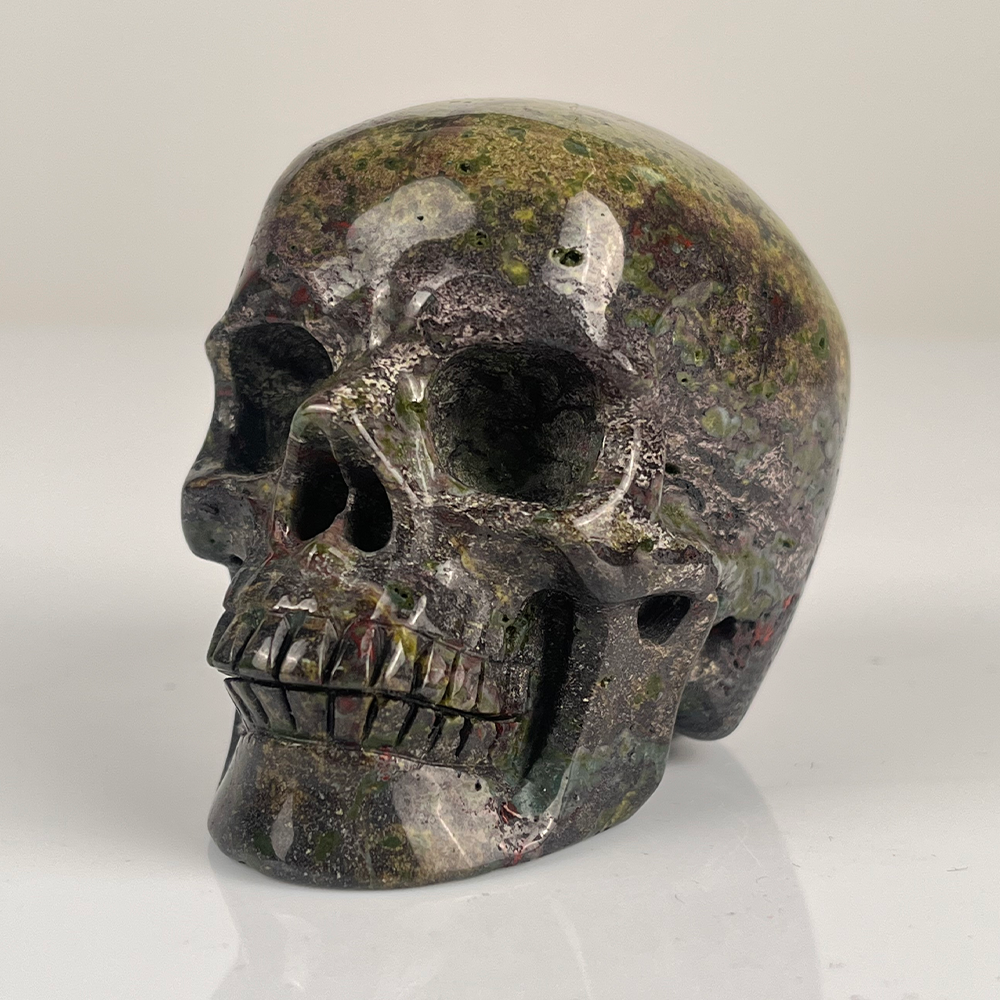 Left-front view of a 3-inch Dragon Bloodstone human skull carving