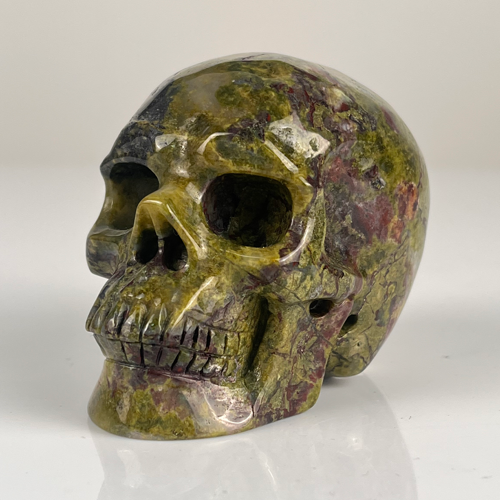 Left-front view of a 3-inch Dragon Bloodstone human skull carving