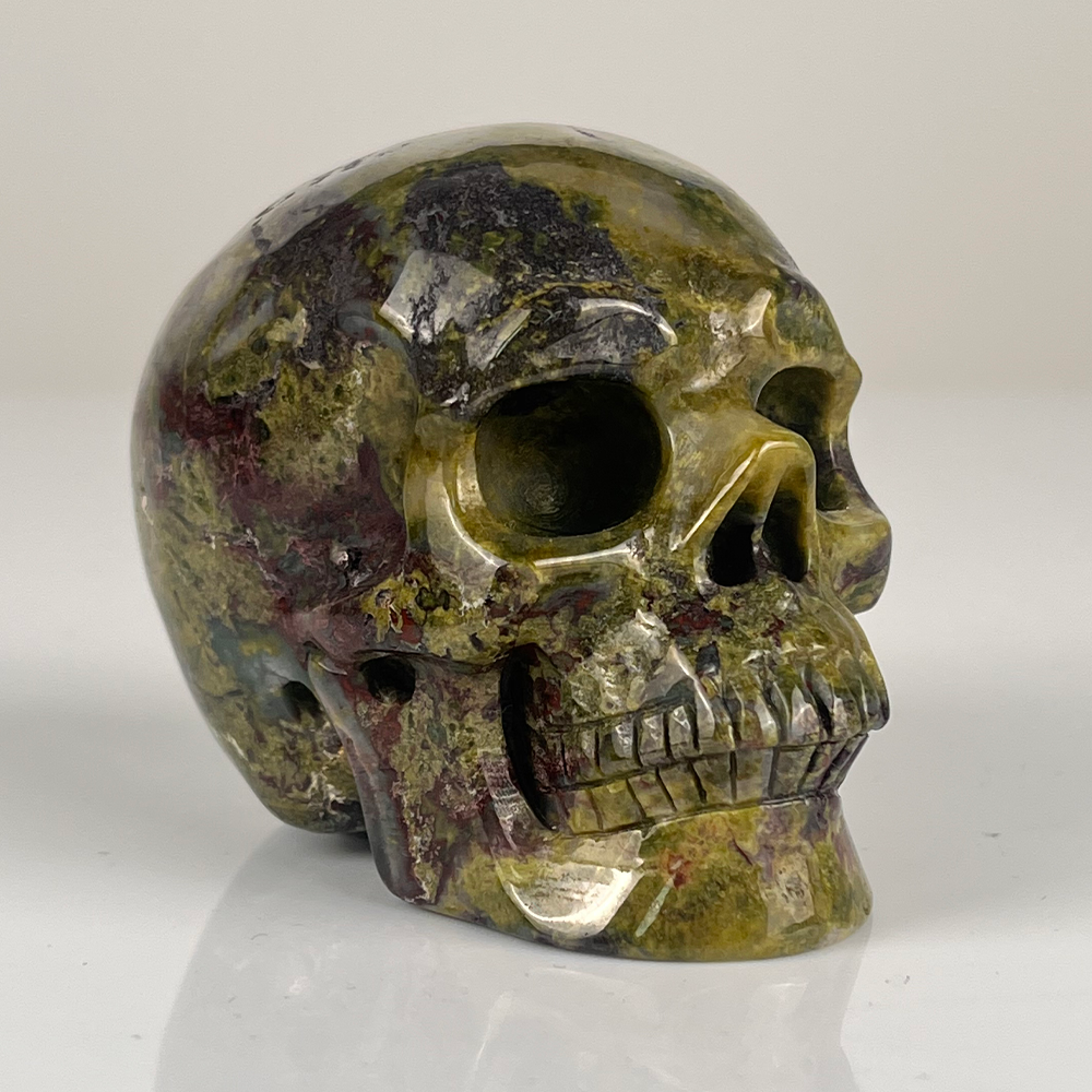 Right-front view of a 3-inch Dragon Bloodstone human skull carving