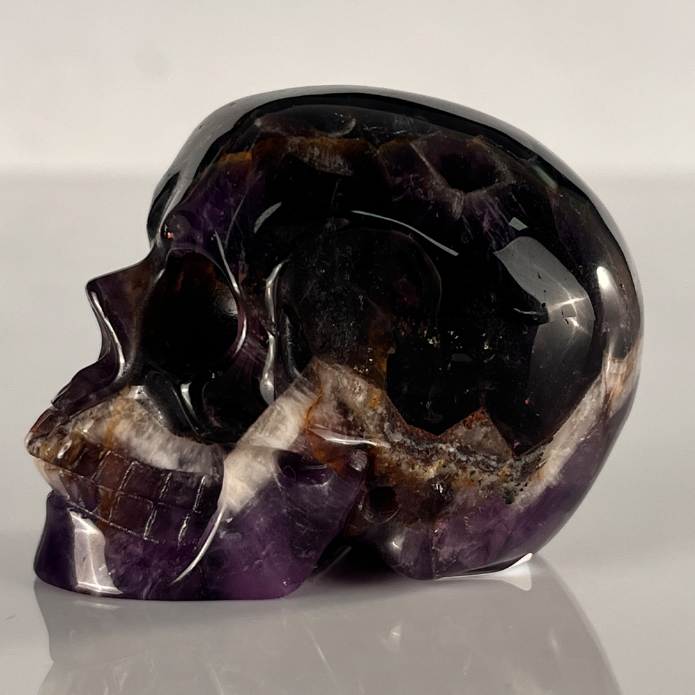 Left view of a 2-inch Dream Amethyst human skull carving