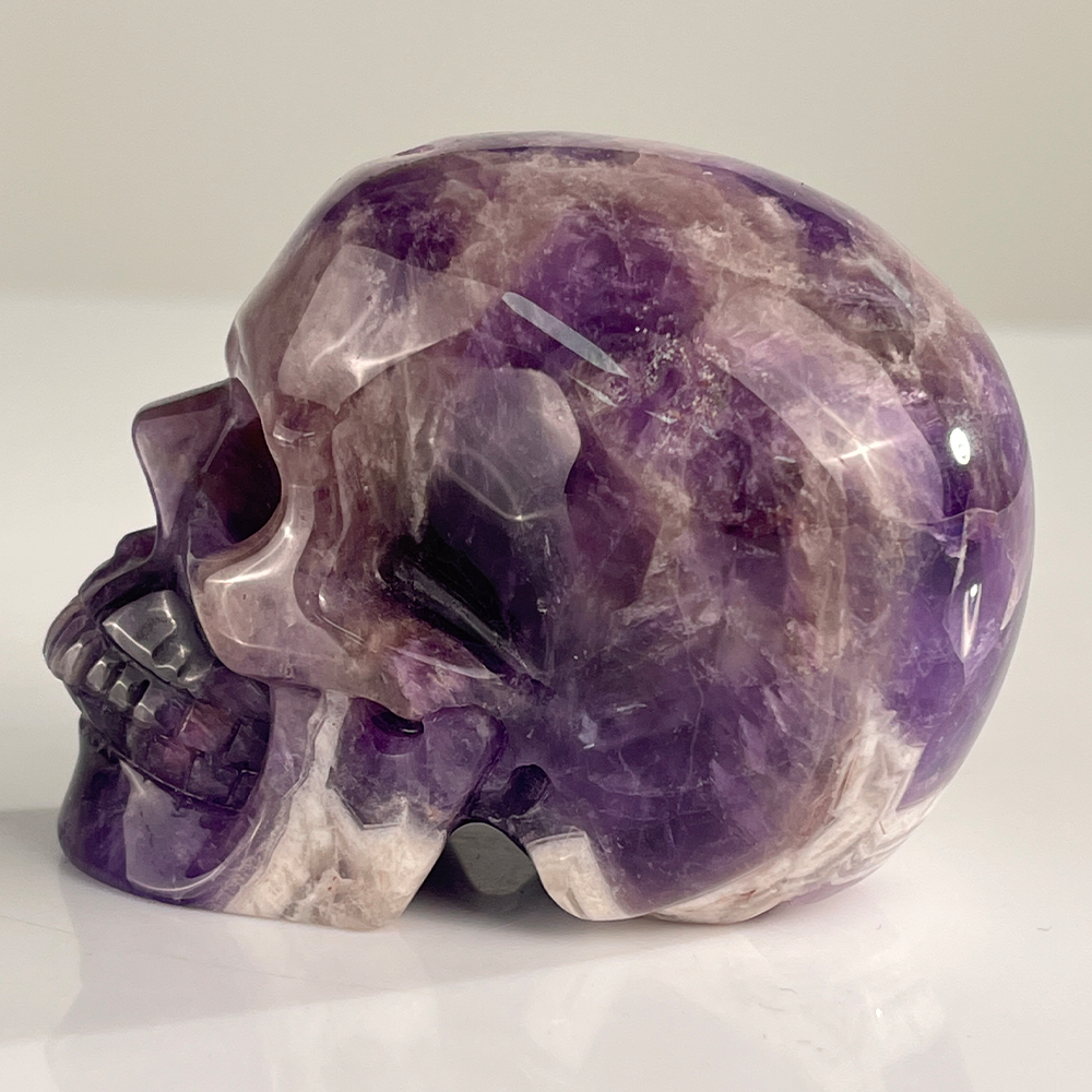 Left view of a 3-inch Dream Amethyst human skull carving