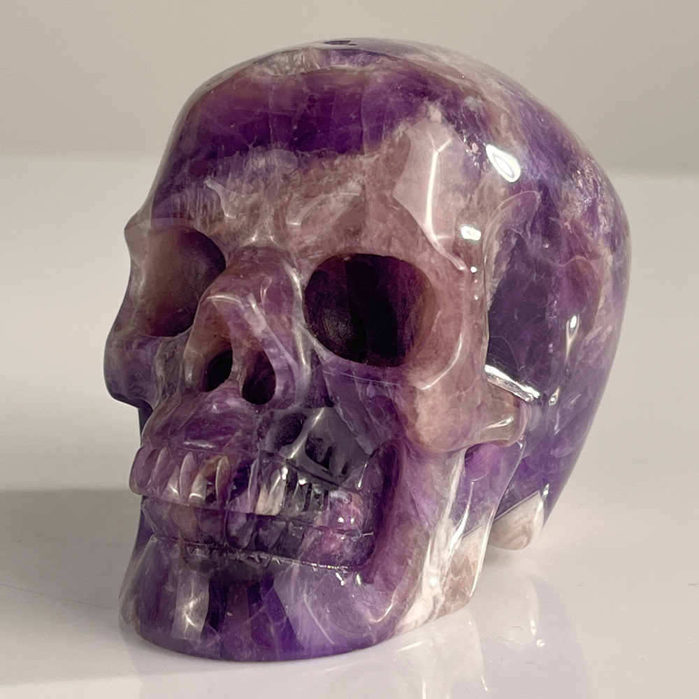 Left-front view of a 3-inch Dream Amethyst human skull carving
