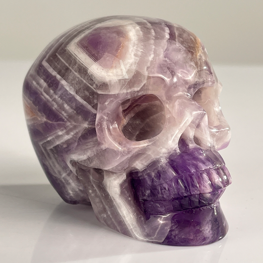 Right-front view of a 3-inch Dream Amethyst human skull carving