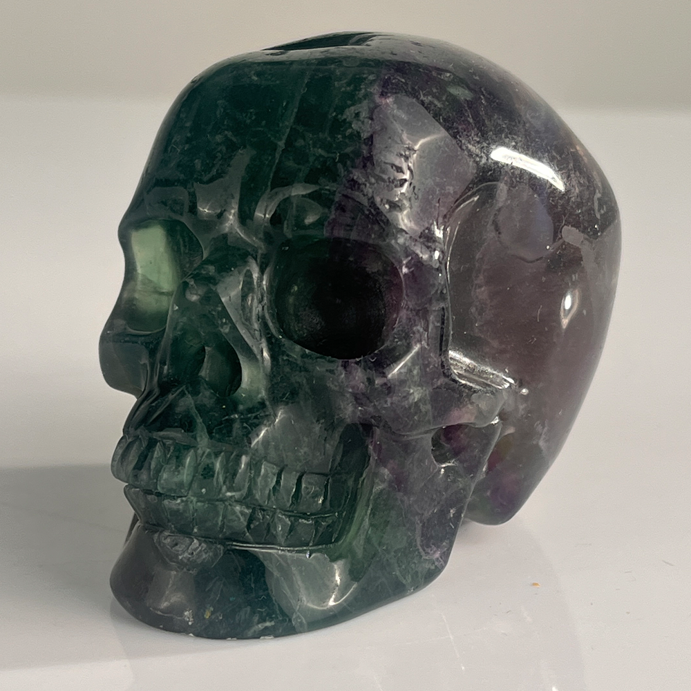 Left-front view of a 3-inch Fluorite human skull carving