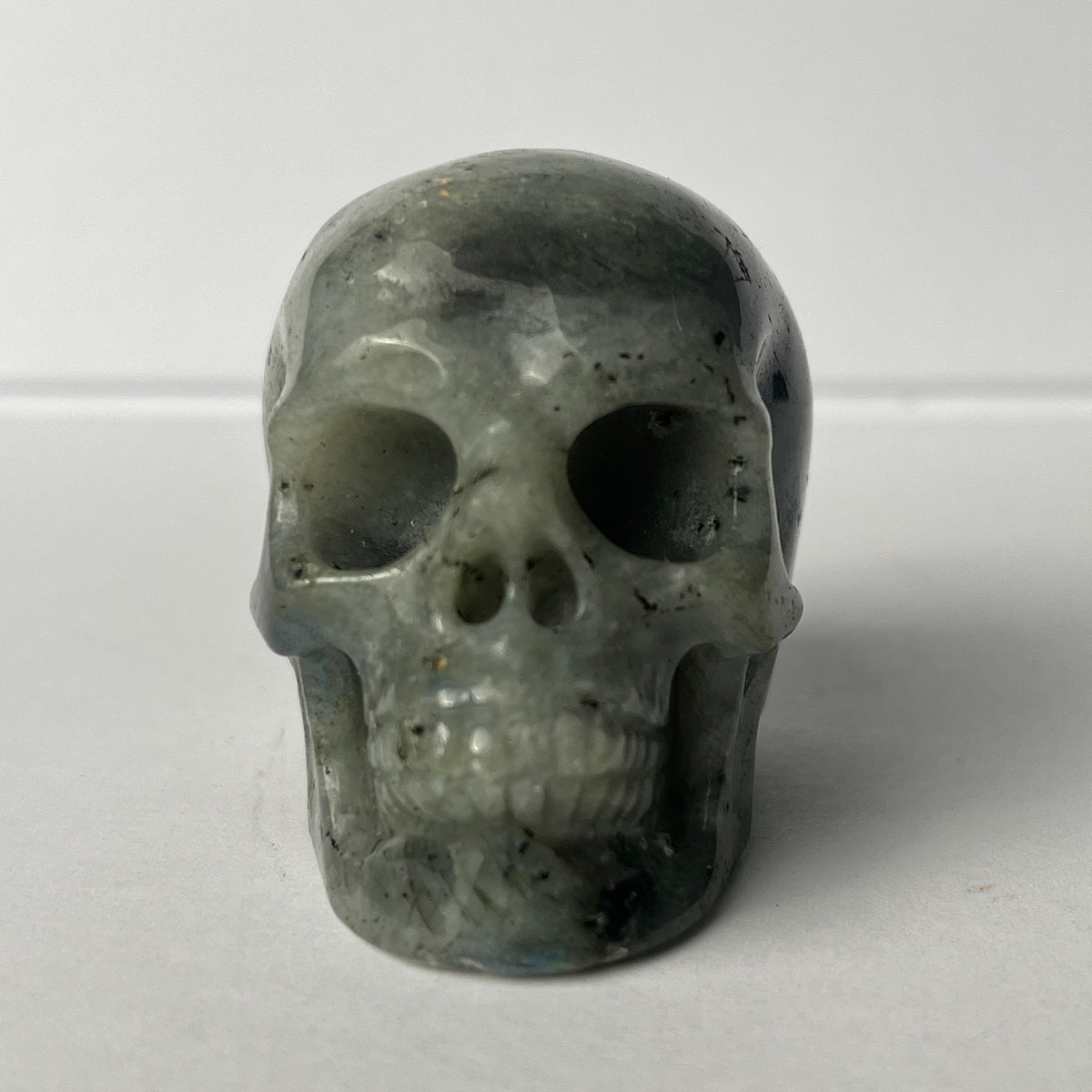 Front view of a 2-inch Grey Labradorite human skull carving