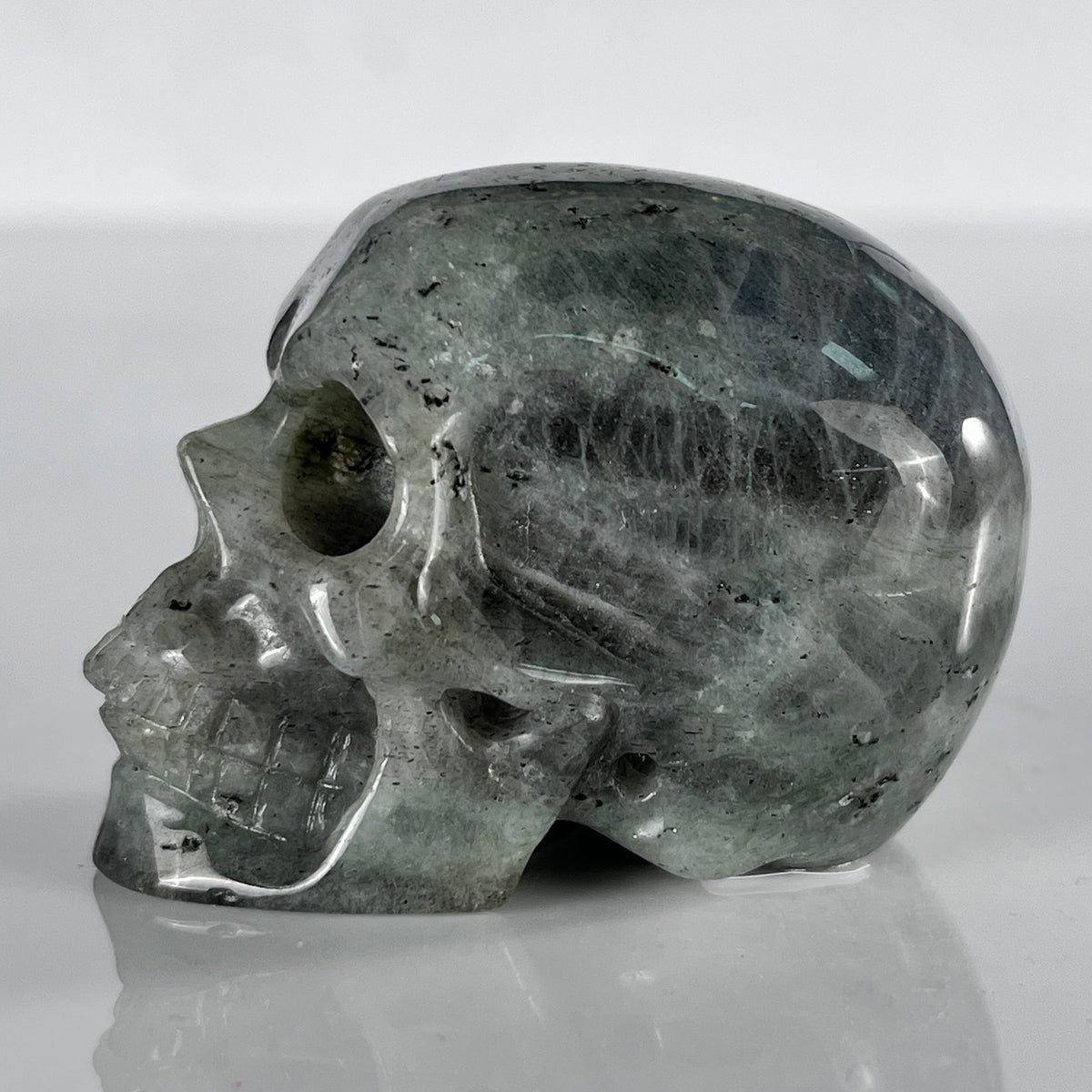 Left view of a 2-inch Grey Labradorite human skull carving