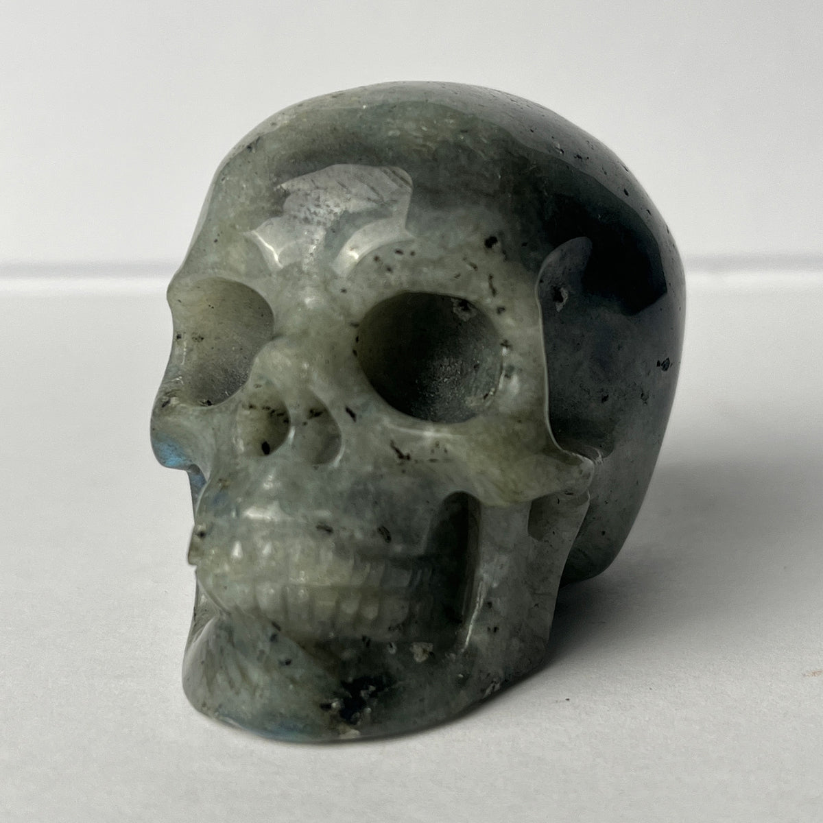 Left-front view of a 2-inch Grey Labradorite human skull carving