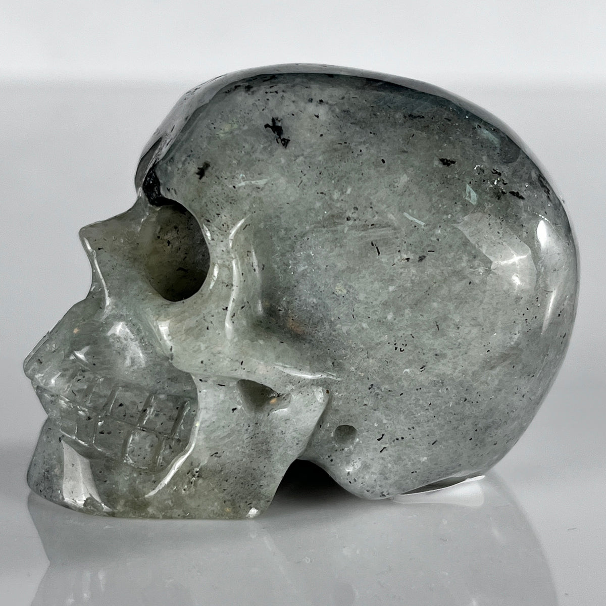 Left view of a 2-inch Grey Labradorite human skull carving