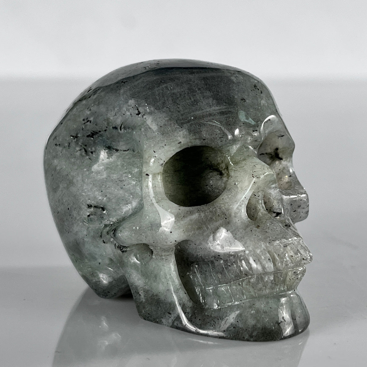 Right-front view of a 2-inch Grey Labradorite human skull carving